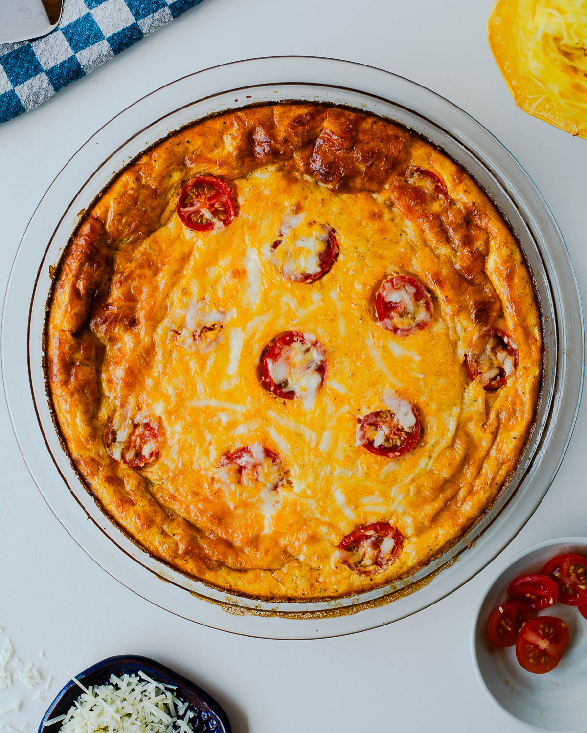 Baked spaghetti squash crustless quiche golden brown with melted cheese and roasted tomatoes