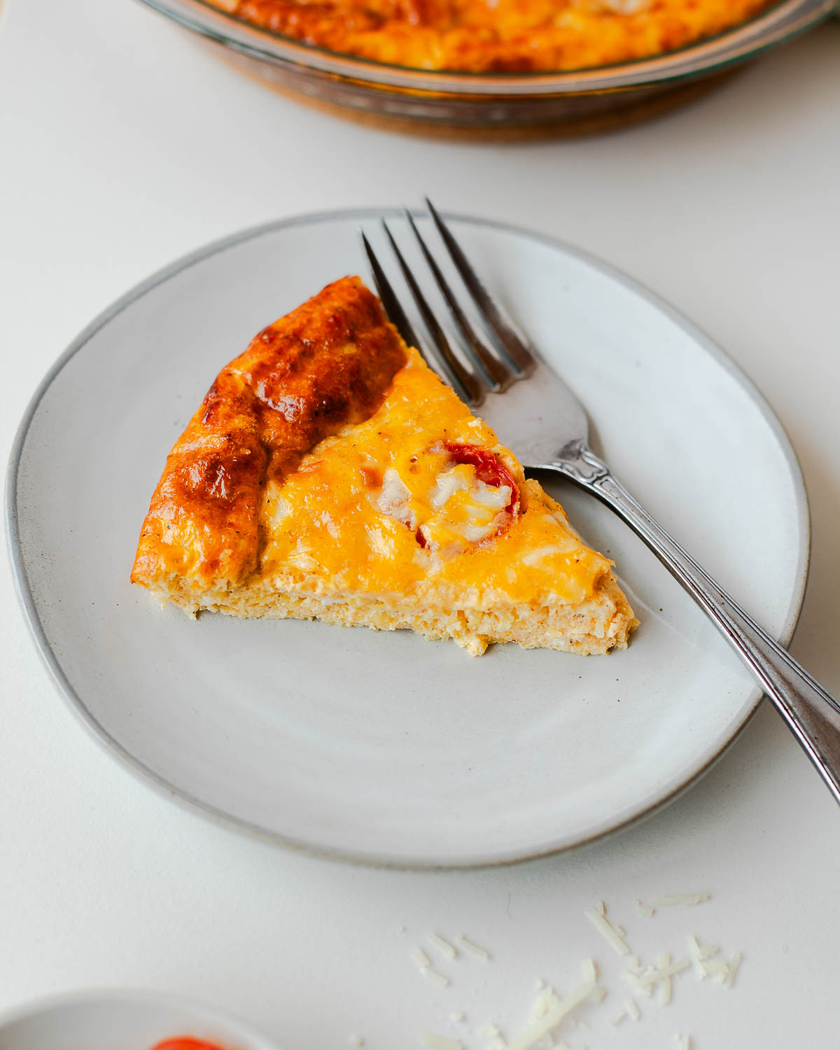 Slice of crustless quiche made with spaghetti squash served on a plate with fork