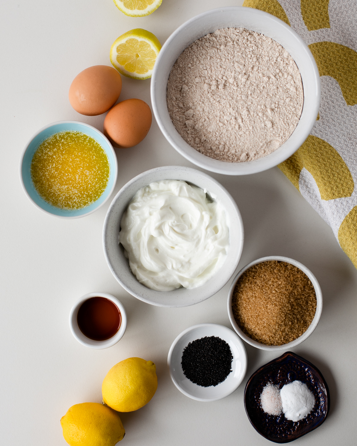 Ingredients for whole wheat lemon poppy seed bread: flour, Greek yogurt, lemons, eggs, sugar, poppy seeds