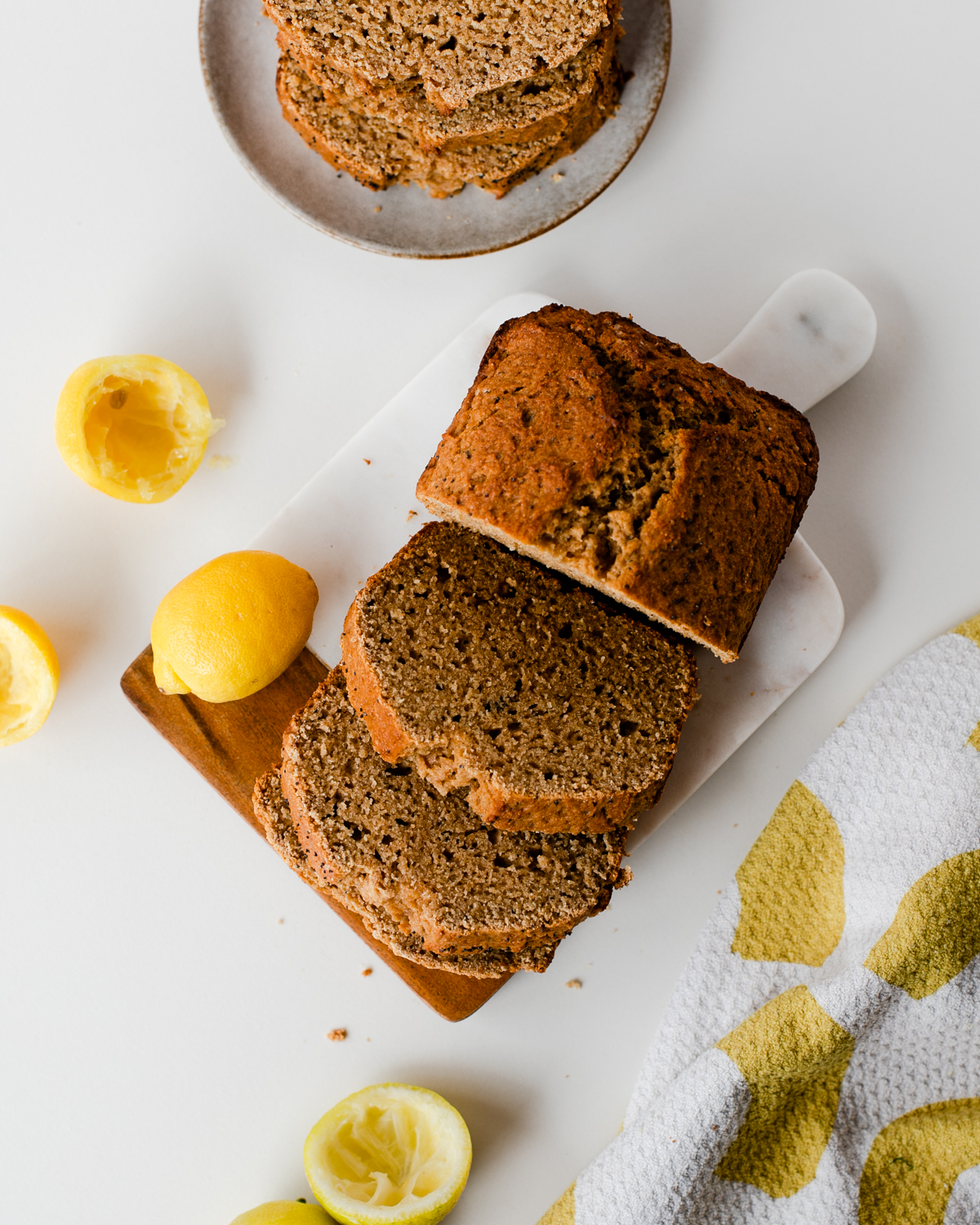 Overhead of sliced whole wheat lemon poppy seed loaf with squeezed lemon halves