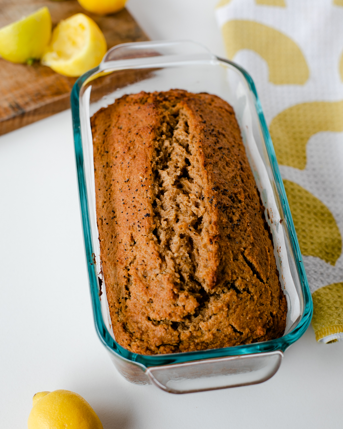 Freshly baked whole wheat lemon poppy seed loaf cooling in a glass pan