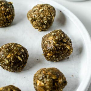 Close-up of homemade no-bake matcha protein balls with rolled oats, hemp hearts, and almond butter.