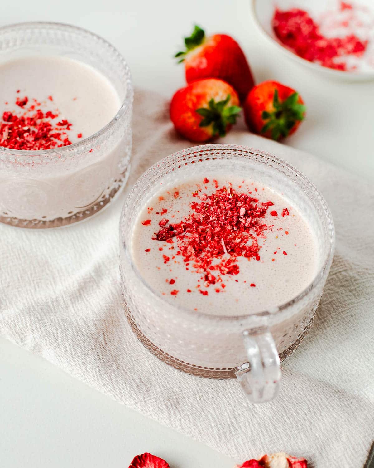 strawberry hot chocolate in 2 mugs with fresh strawberries