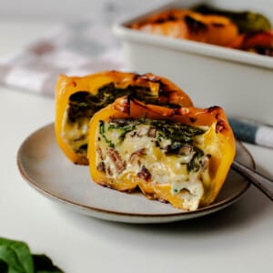 Close-up of breakfast stuffed pepper half, creamy eggs with bacon and spinach.