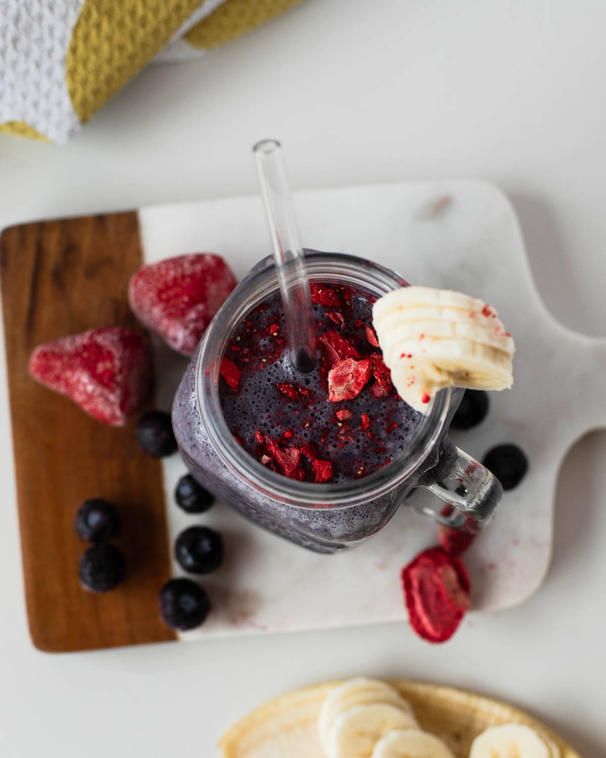 Overhead of purple berry egg white shake sprinkled with freeze-dried strawberry pieces.
