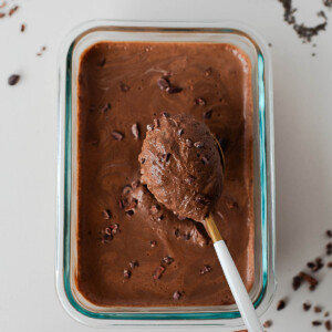 Spoon lifting thick, creamy chocolate protein chia pudding to show set texture.