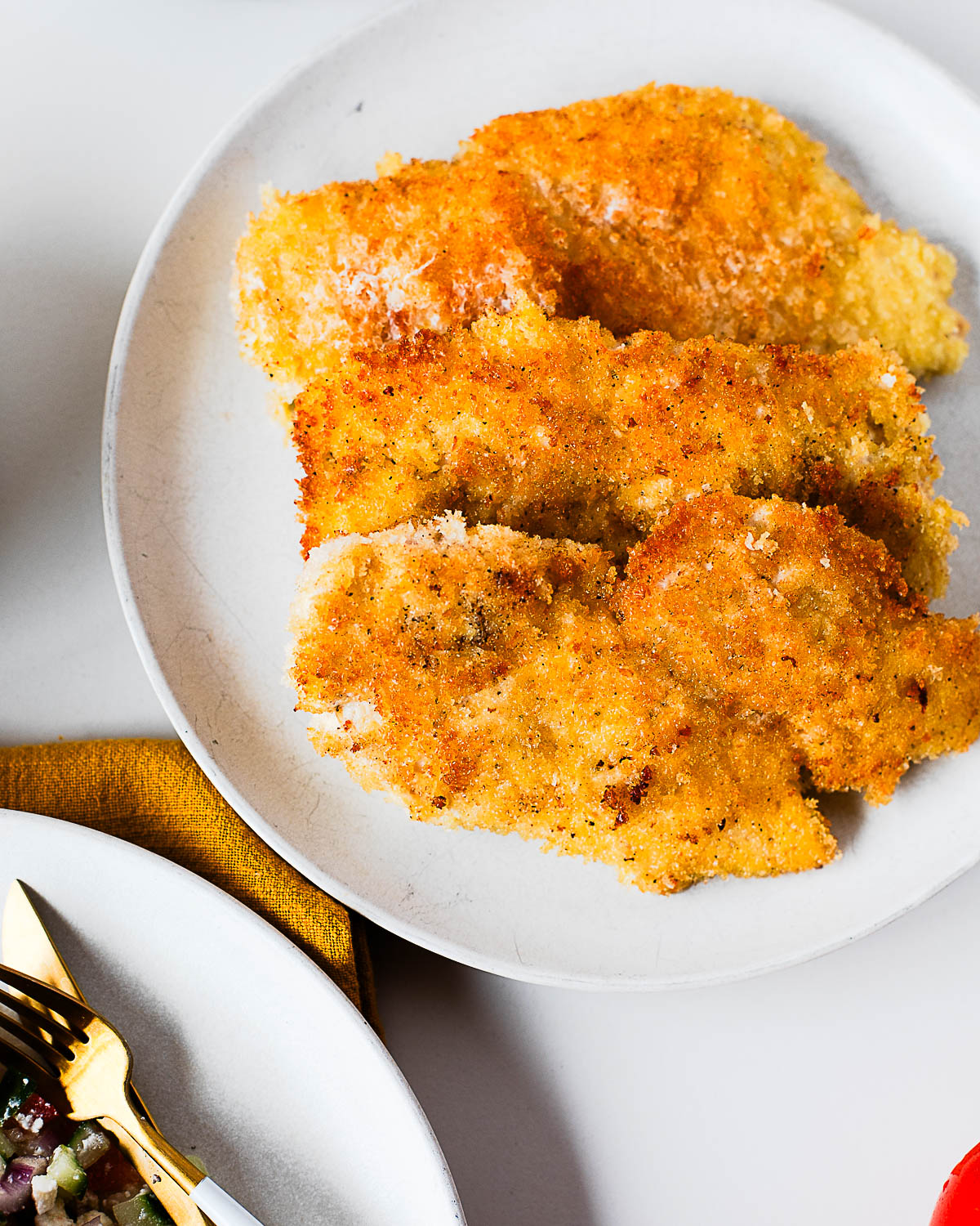 Plate of four crispy panko chicken cutlets, golden and crunchy.