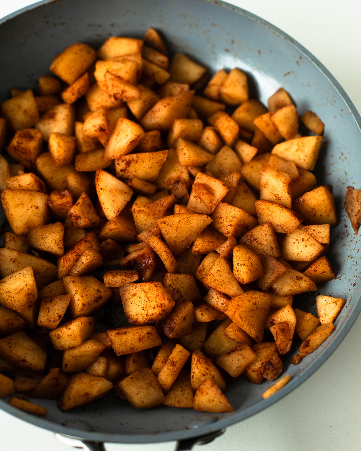 Cinnamon apples simmered until soft and golden brown, ready to top mini cheesecakes