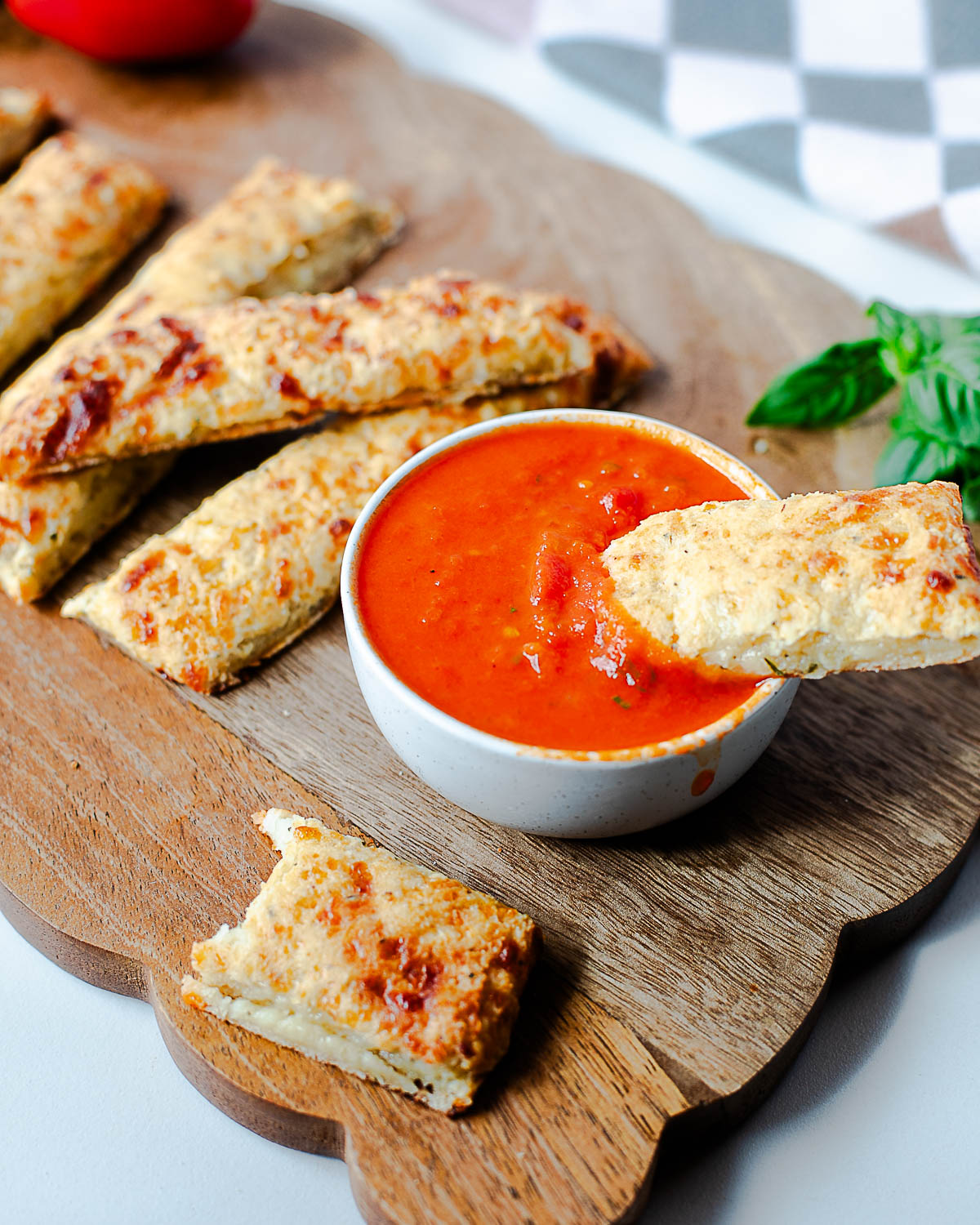 lose-up of cottage cheese breadstick dipped into red sauce for serving