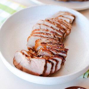Side angle view of sliced Asian pork tenderloin showing tender texture and caramelized crust on each piece.