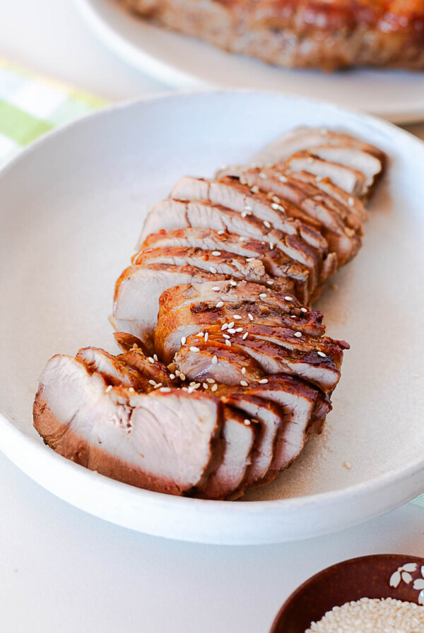 Side angle view of sliced Asian pork tenderloin showing tender texture and caramelized crust on each piece.