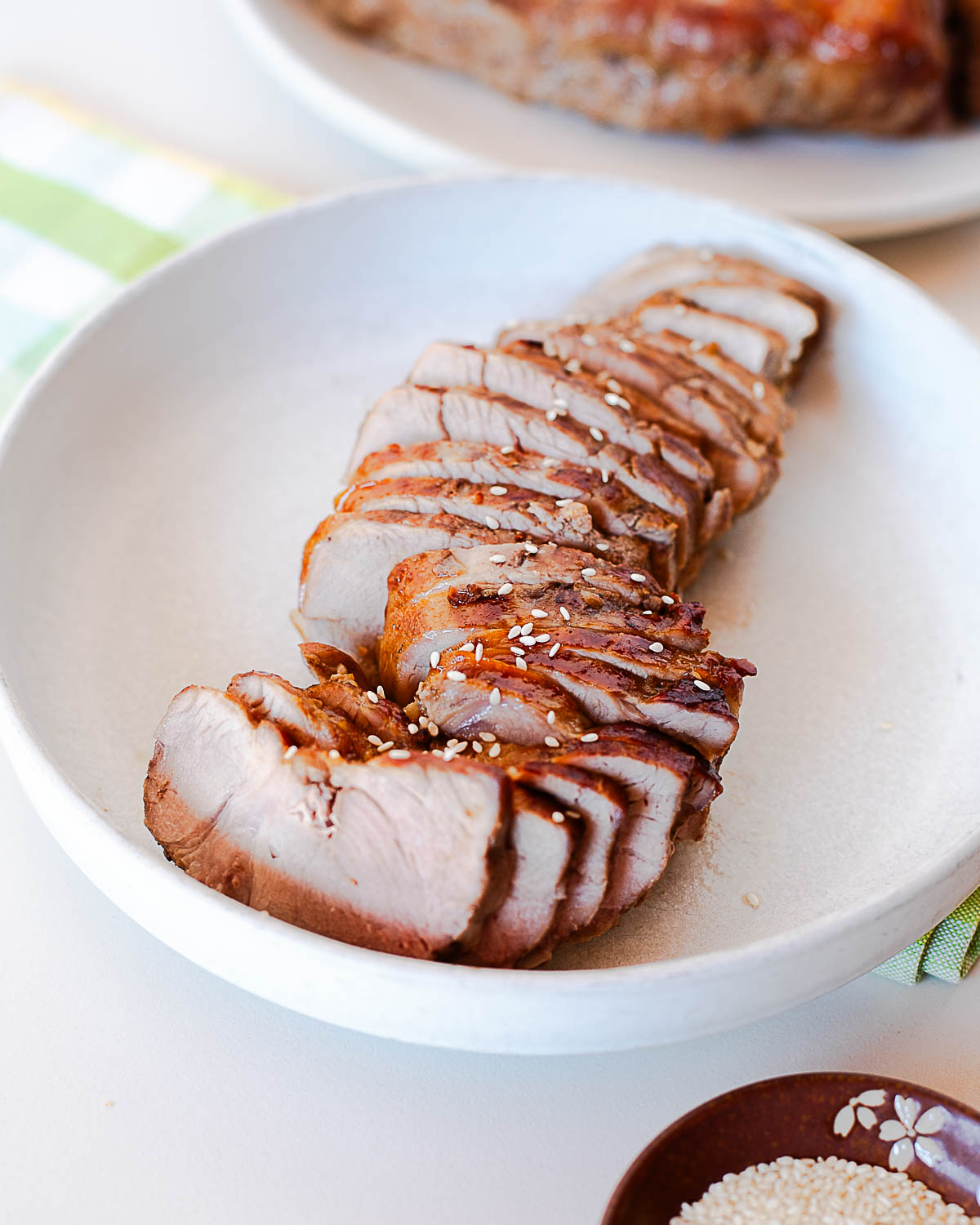 Side angle view of sliced Asian pork tenderloin showing tender texture and caramelized crust on each piece.