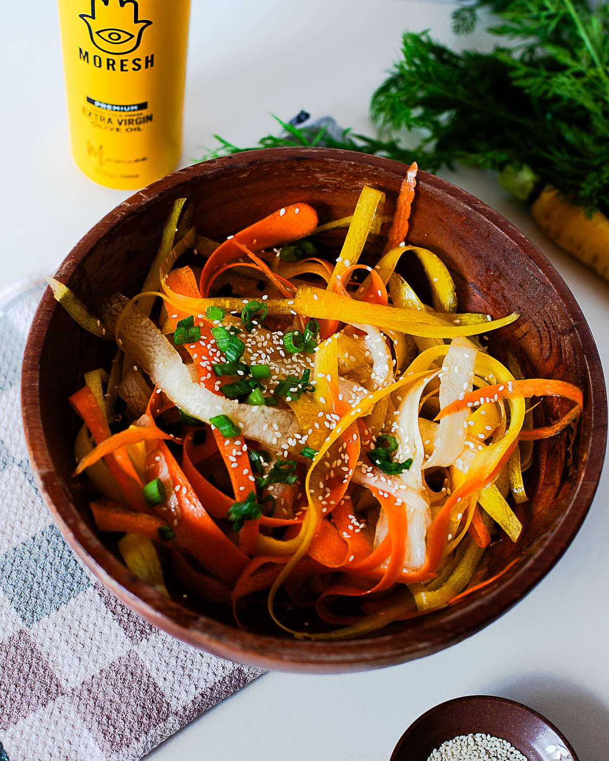 Close-up of vibrant carrot ribbon salad tossed in a light olive oil, rice vinegar, and coconut aminos dressing