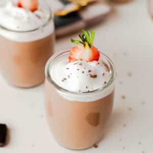 Chocolate cottage cheese pudding with creamy whipped topping and chocolate shavings in a small glass jar.