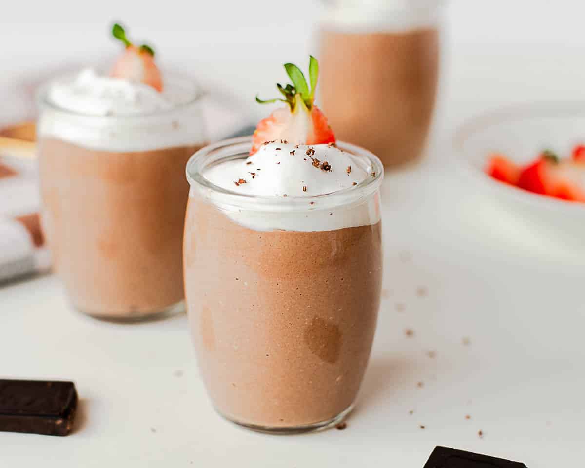 Healthy cottage cheese chocolate pudding styled as a high protein dessert with fresh strawberries and chocolate pieces.