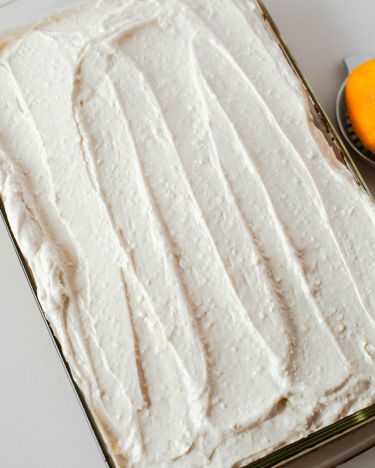 Sweet potato sheet cake fully frosted with a smooth layer of maple cream cheese frosting, creamy and slightly textured.
