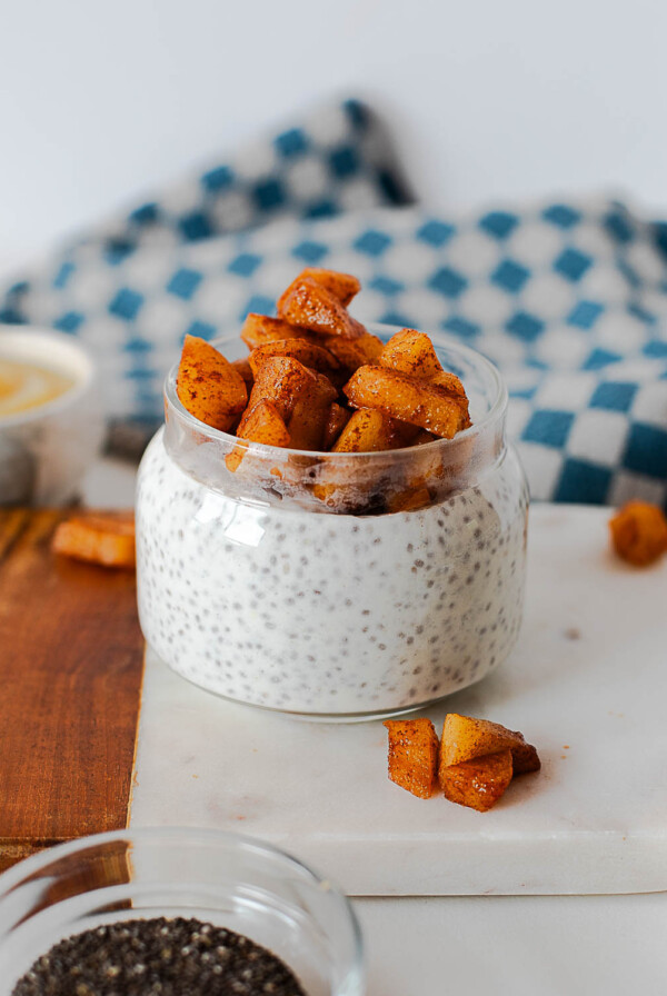 Meal prep apple pie chia pudding jars arranged on a cutting board
