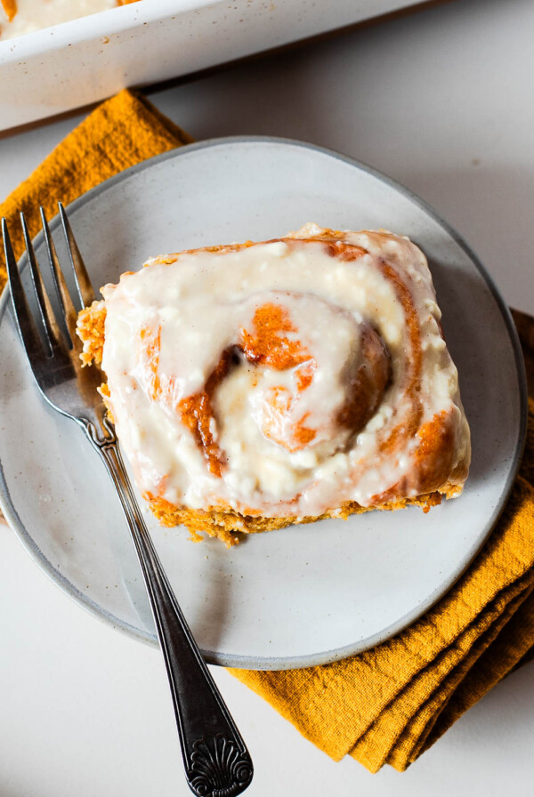 op view of an iced sweet potato cinnamon roll on a plate