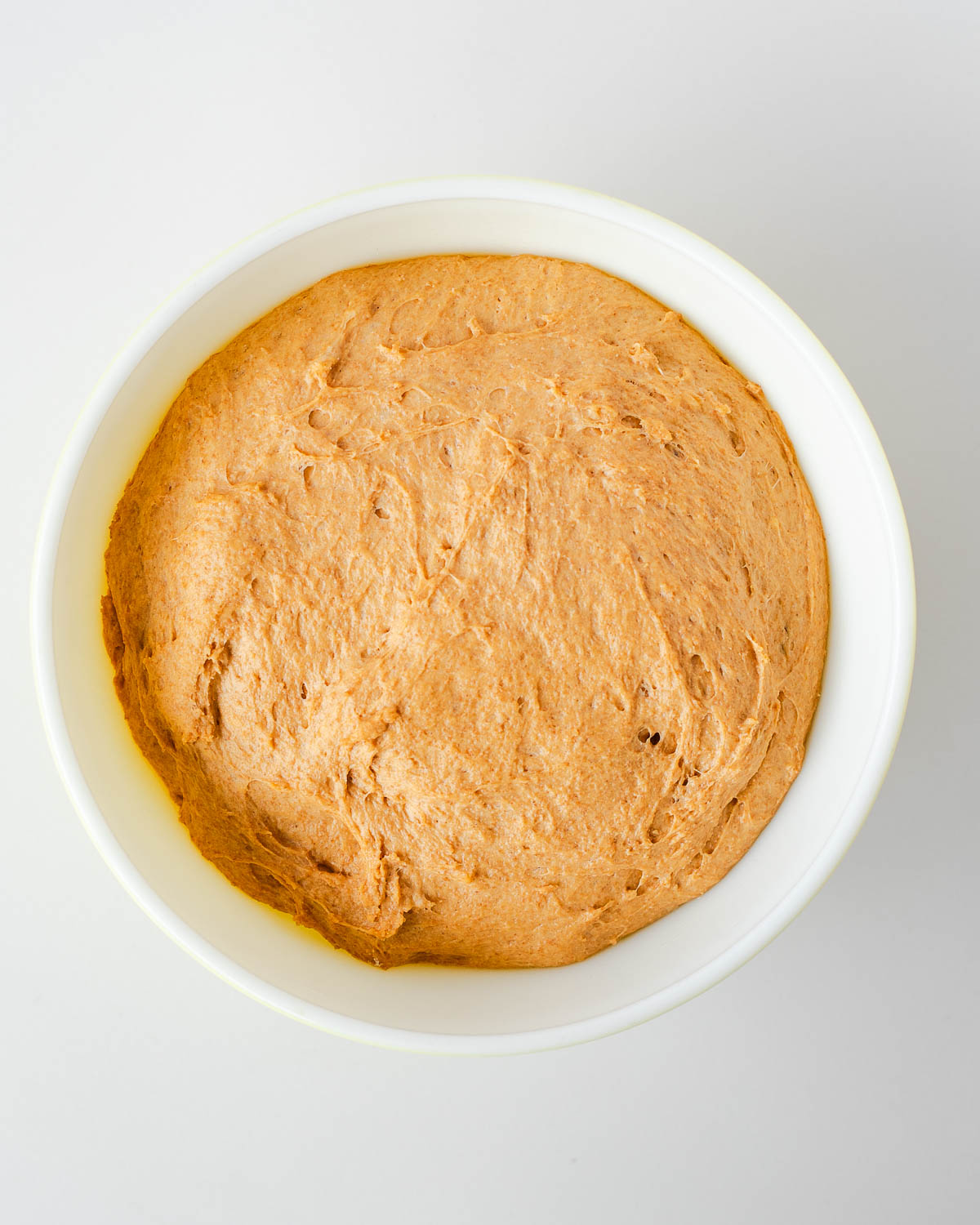 Whole wheat sweet potato cinnamon roll dough after first rise in a bowl