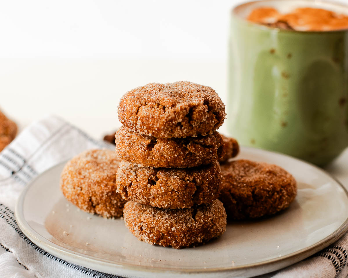 Sweet potato snickerdoodle cookies arranged in small stacks on a neutral plate