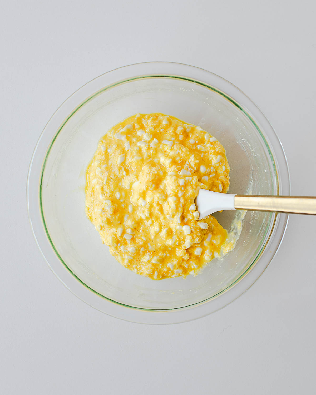 Cottage cheese pizza bite batter mixed in a glass bowl with eggs and coconut flour