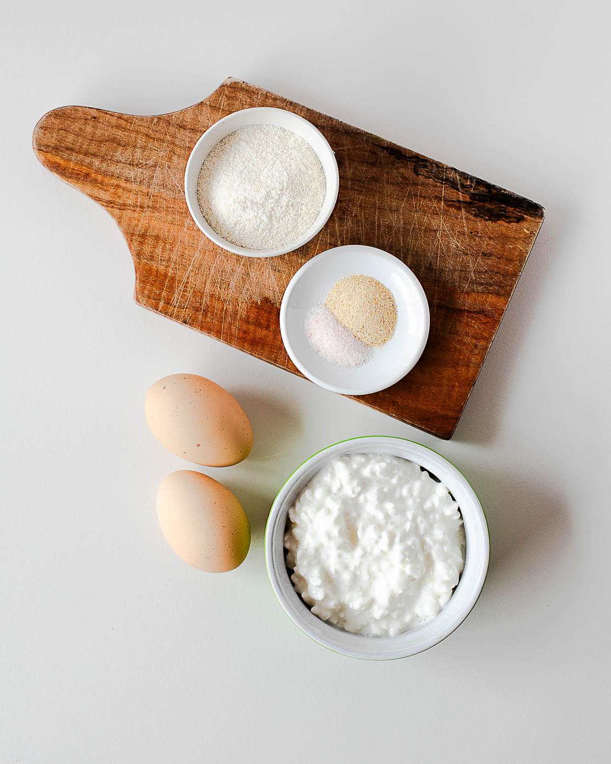 Ingredients for cottage cheese pizza bites including cottage cheese, eggs, coconut flour, and seasonings