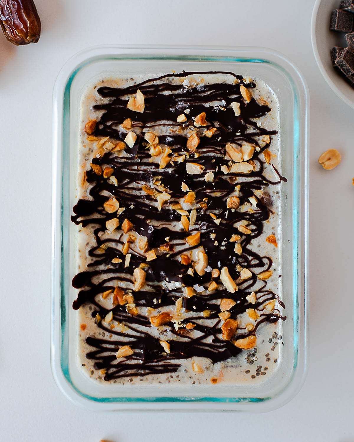 Close-up of Snickers overnight oats with a crackable chocolate shell and crunchy peanut topping