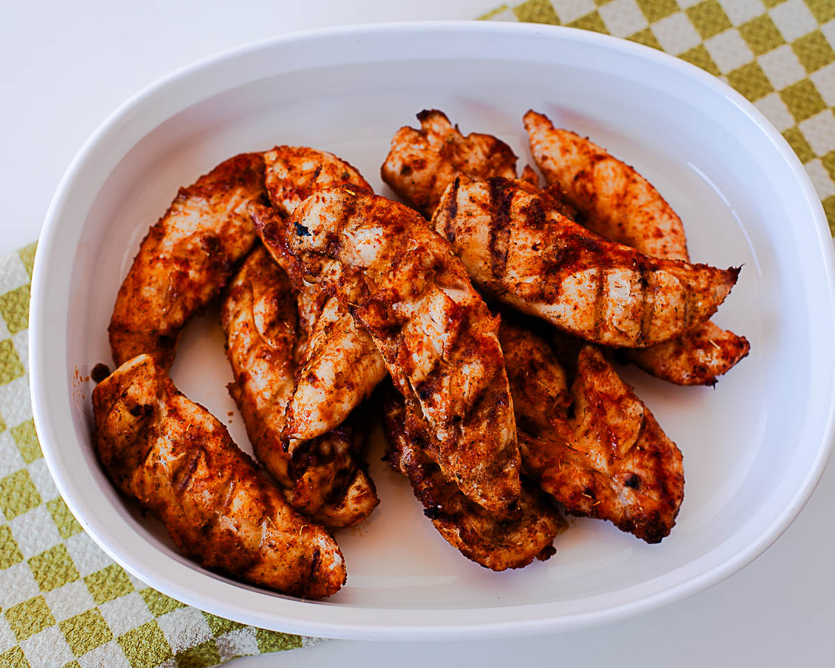 Close-up of juicy Traeger chicken tenders with charred grill marks and seasoning.
