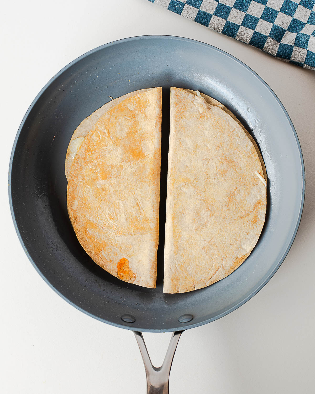 Tuna melt quesadilla cooking in a nonstick skillet until lightly golden and crisp on both sides.