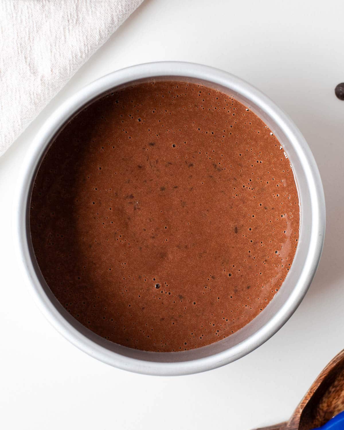 luten-free black bean chocolate cake batter poured into a round cake pan before baking.