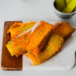 Close-up of golden crunchy cheese crisp folded around pickle and turkey