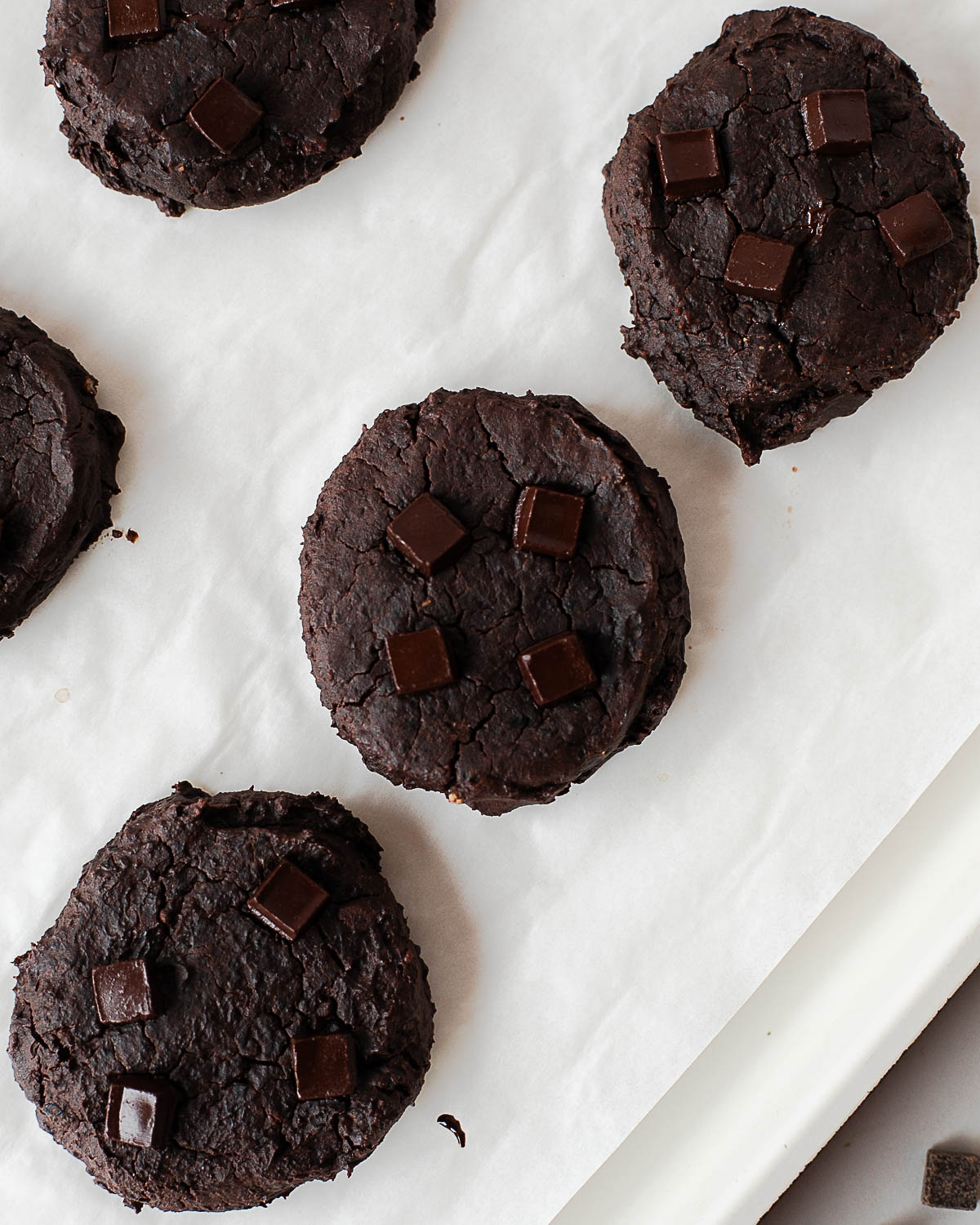 Close-up of fudgy black bean chocolate cookies with cracked tops and melted chocolate