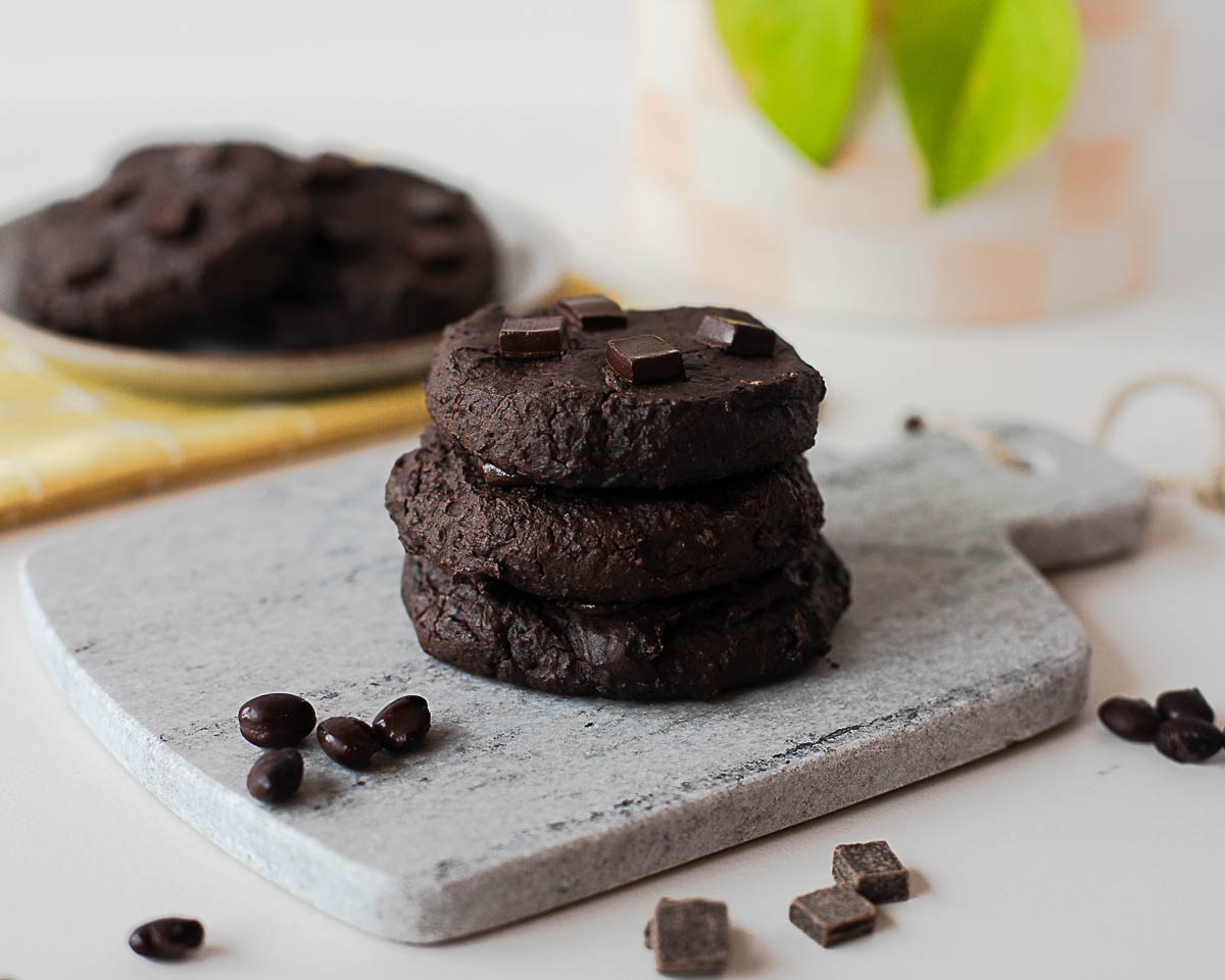 Three stacked black bean cookies showing rich, dense texture and chocolate chunks