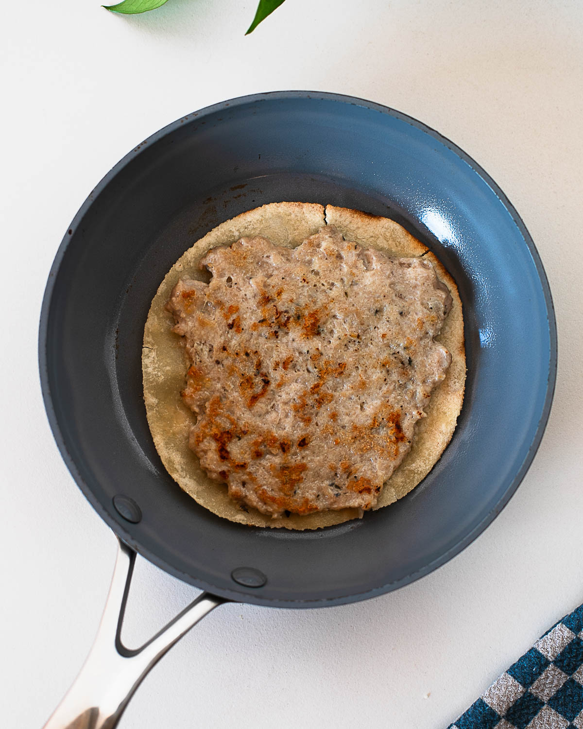 Chicken caesar smash taco cooking meat side down in a skillet until golden and crispy.