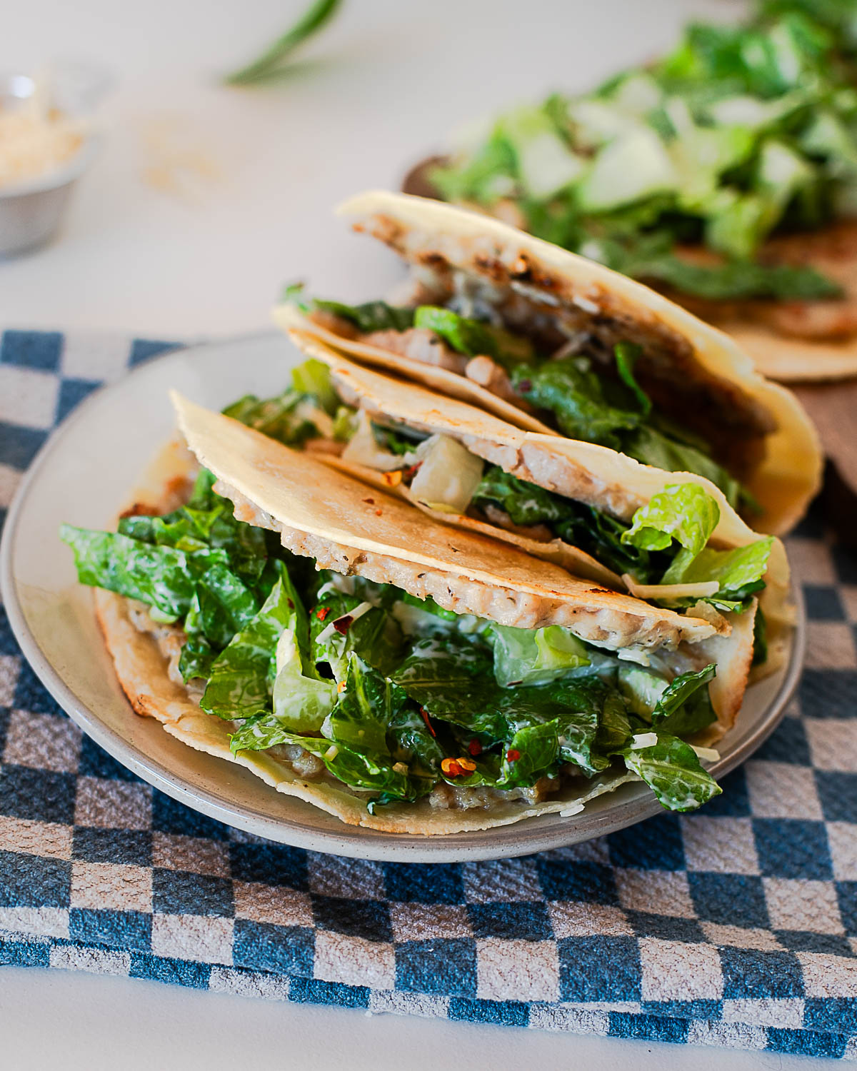 Chicken Caesar smash tacos recipe made with ground chicken smashed onto tortillas and topped with romaine Caesar salad and parmesan.