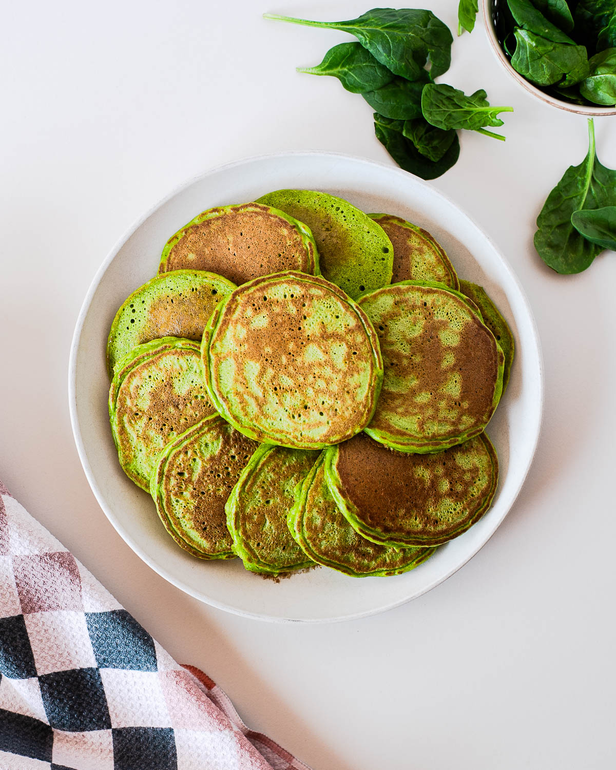 Overhead view of homemade spinach einkorn pancakes on a plate