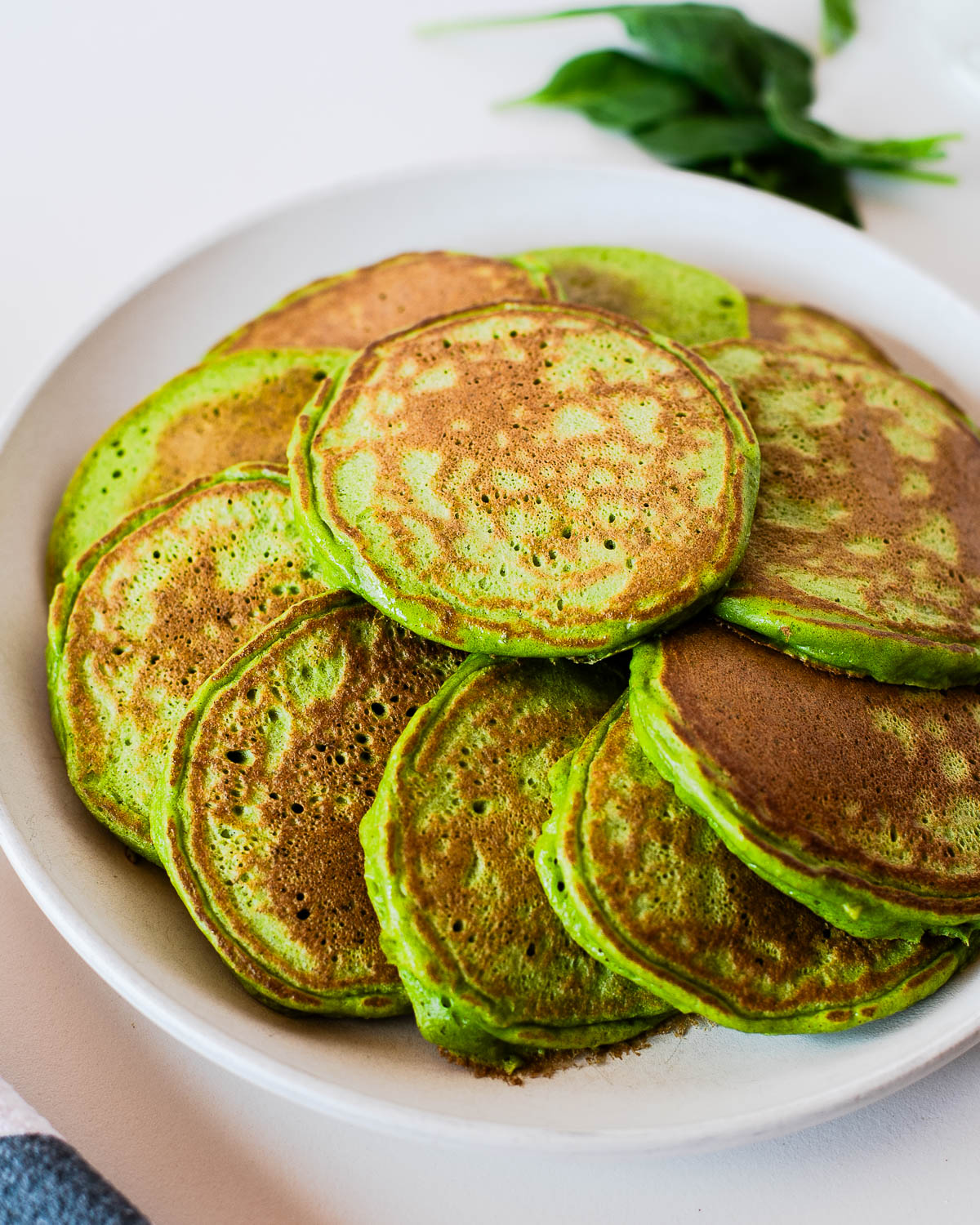 Close-up of fluffy green pancakes made with spinach and einkorn flour