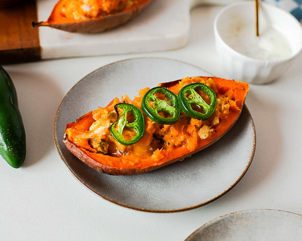 Close up of cheesy jalapeño popper sweet potato with bacon and chicken