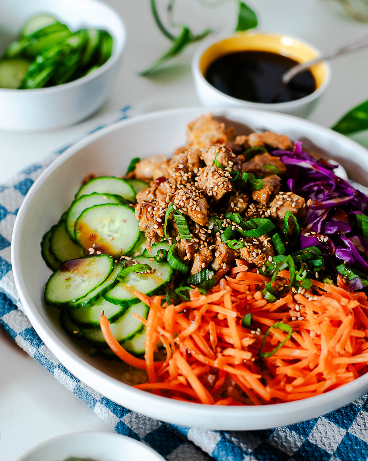 Balanced Korean BBQ chicken bowl with fresh veggies and sesame seeds served over cauliflower rice.