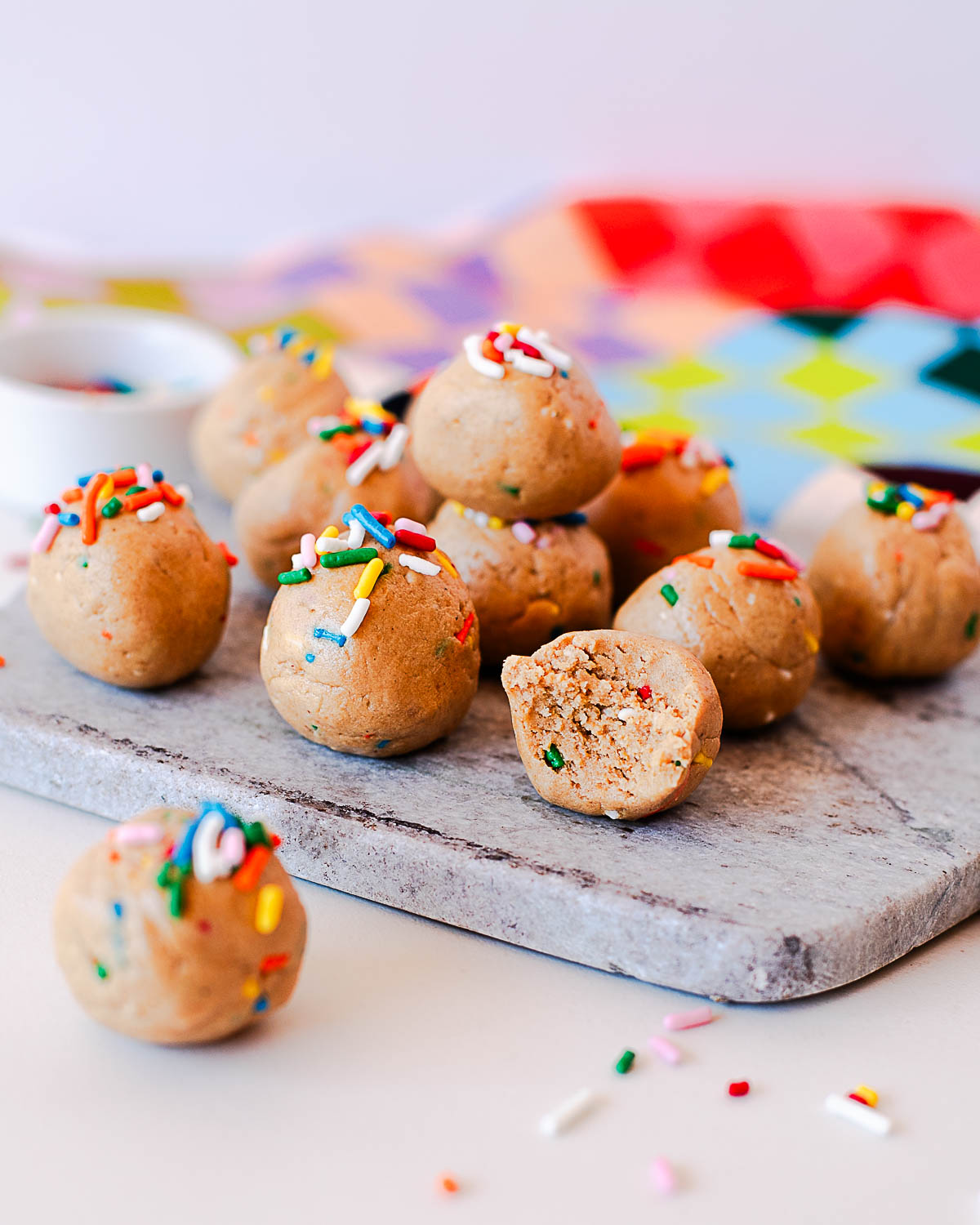 Birthday cake protein balls stacked and styled for serving with a fun sprinkle topping.