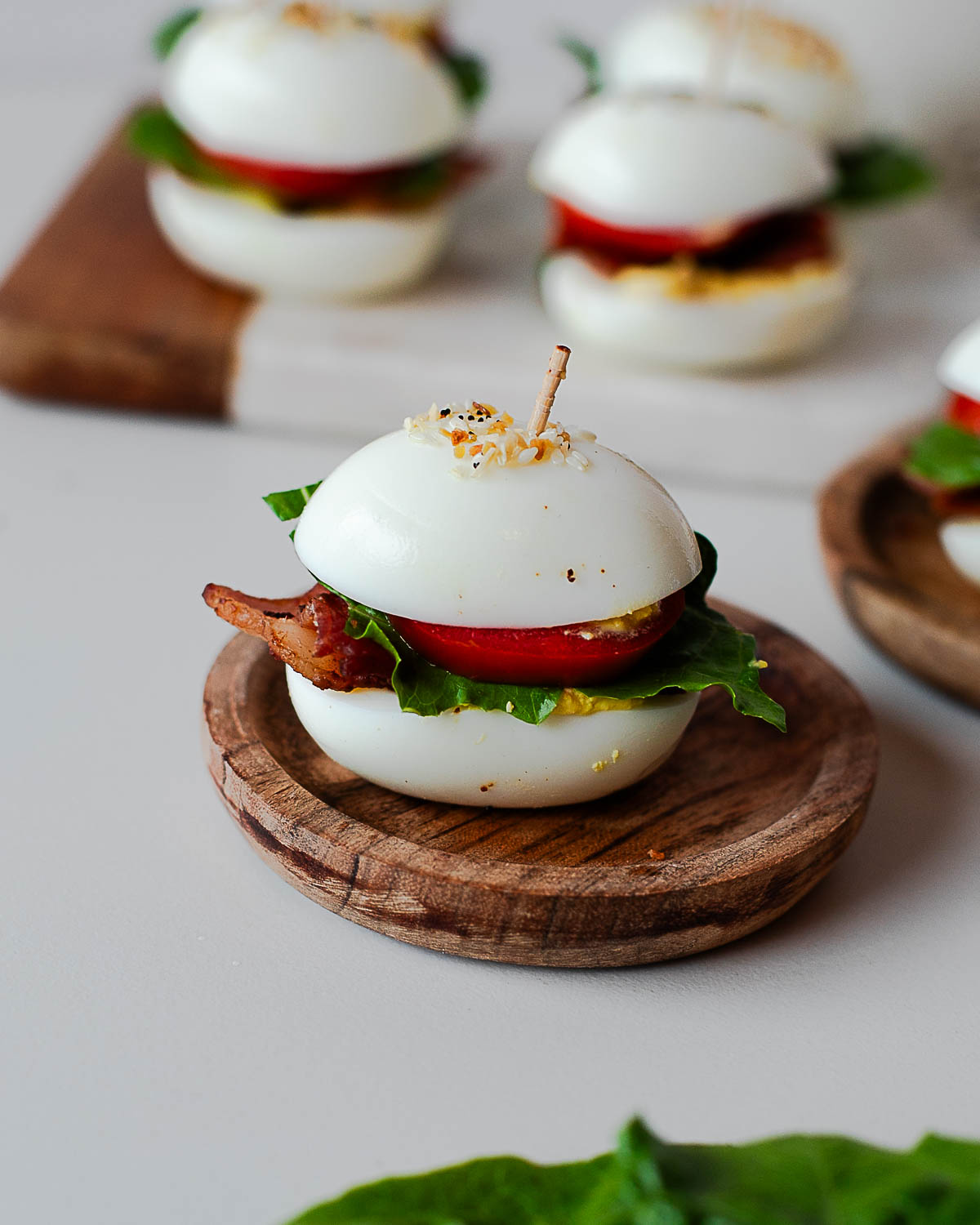 BLT deviled egg sliders topped with everything bagel seasoning and secured with toothpicks