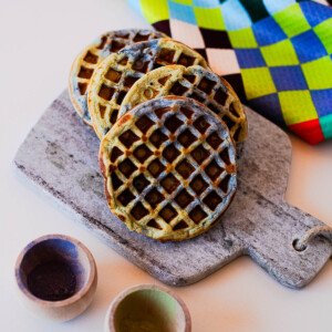 Stack of Earth Day waffles with blue and green swirls on a stone board with natural powders