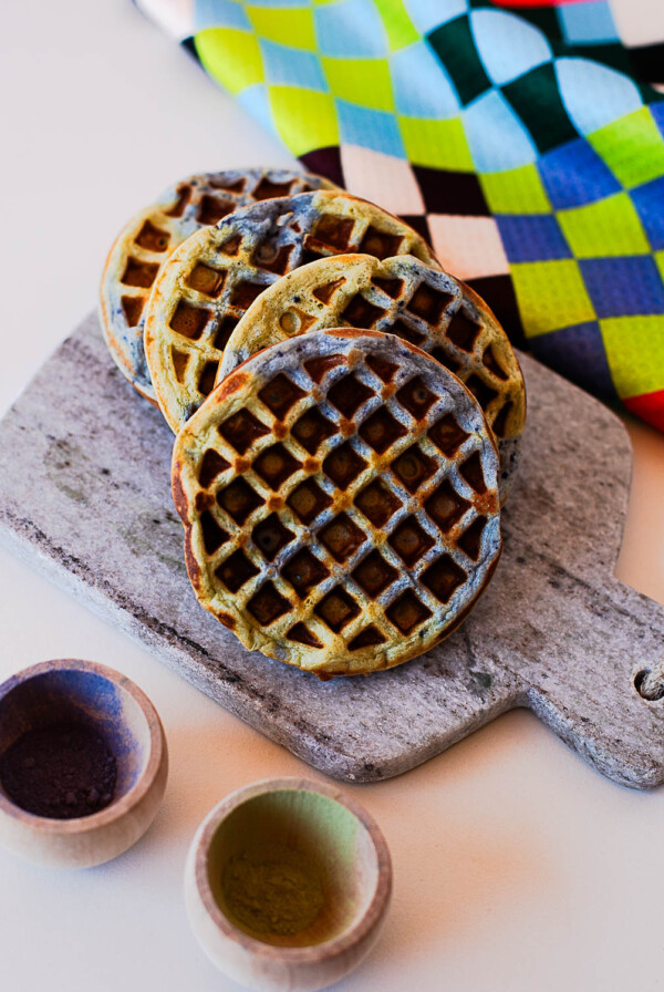 Stack of Earth Day waffles with blue and green swirls on a stone board with natural powders
