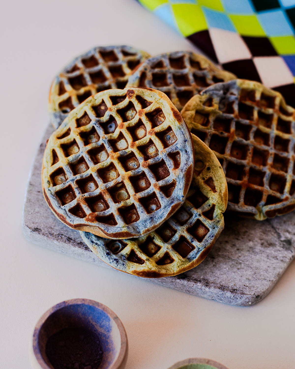 Close up of colorful Earth Day waffles with crispy edges and green and blue swirl pattern