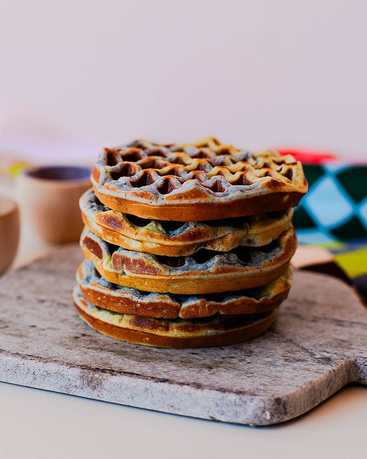 Golden brown Earth Day waffles with blue and green marbling stacked for a high protein breakfast