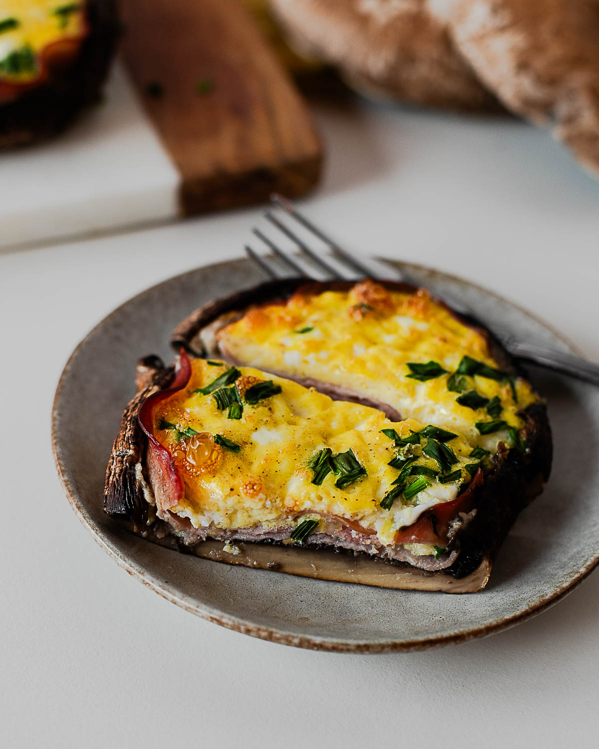 Close-up of baked portobello mushroom filled with eggs, ham, and cottage cheese
