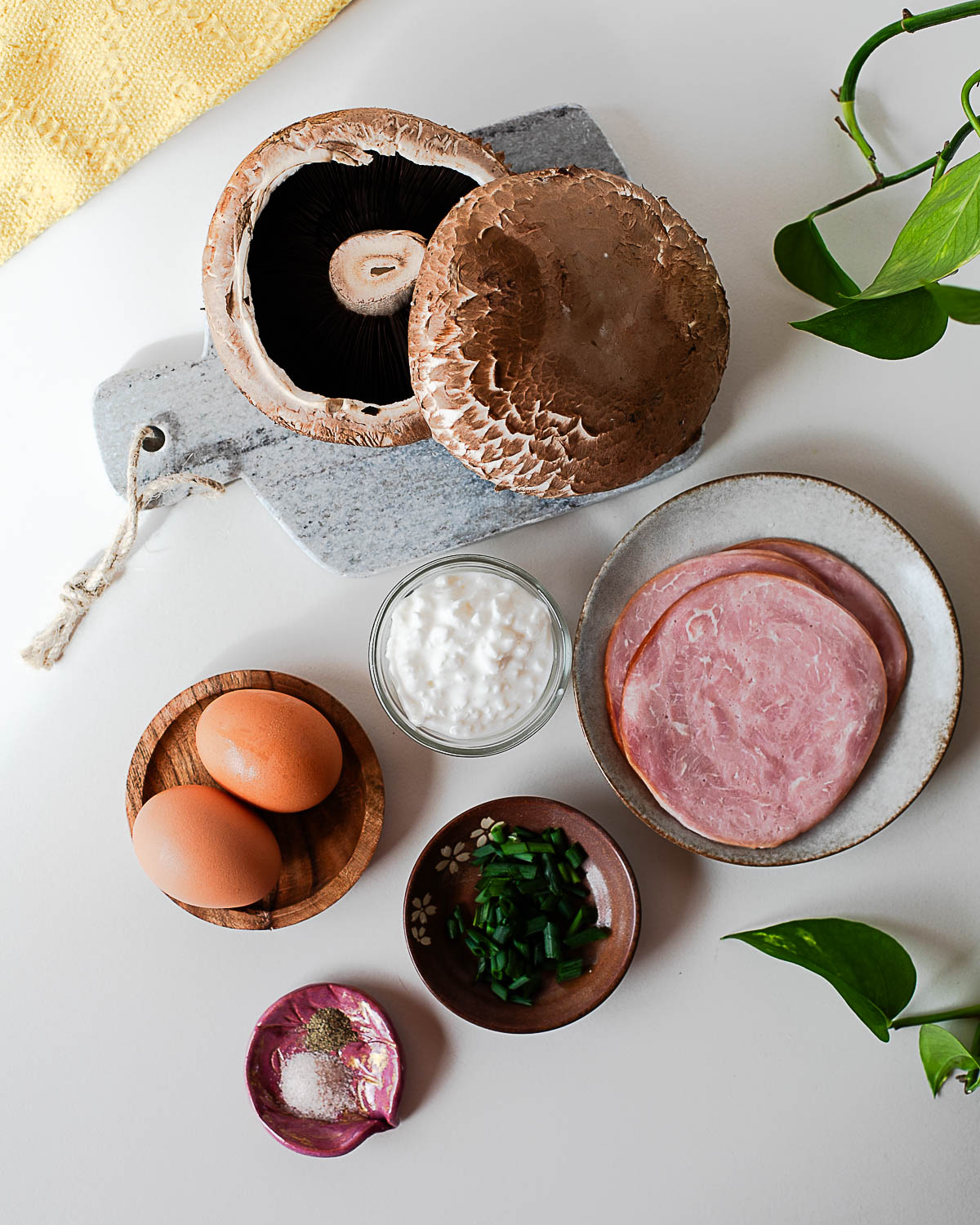 Ingredients for breakfast stuffed portobello mushrooms including eggs, cottage cheese, ham, chives, and large mushroom caps