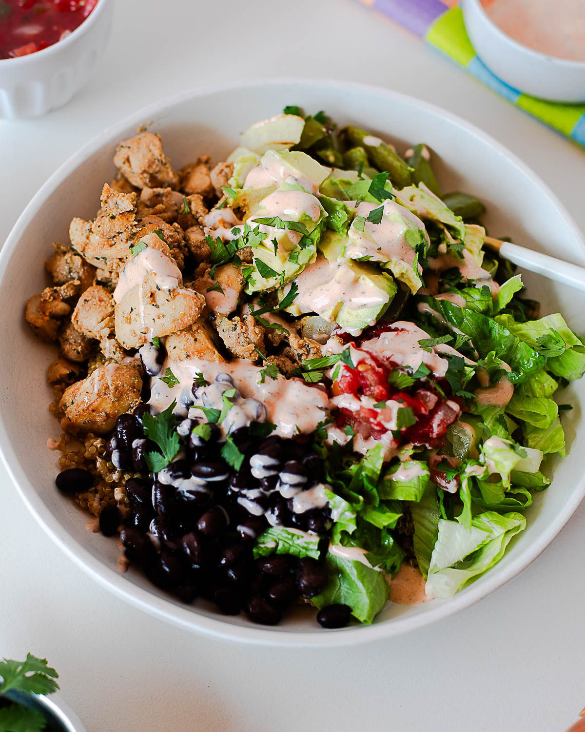 Southwest chicken burrito bowl with Isernio’s chipotle lime chicken meal starters, quinoa, beans, and fresh toppings.