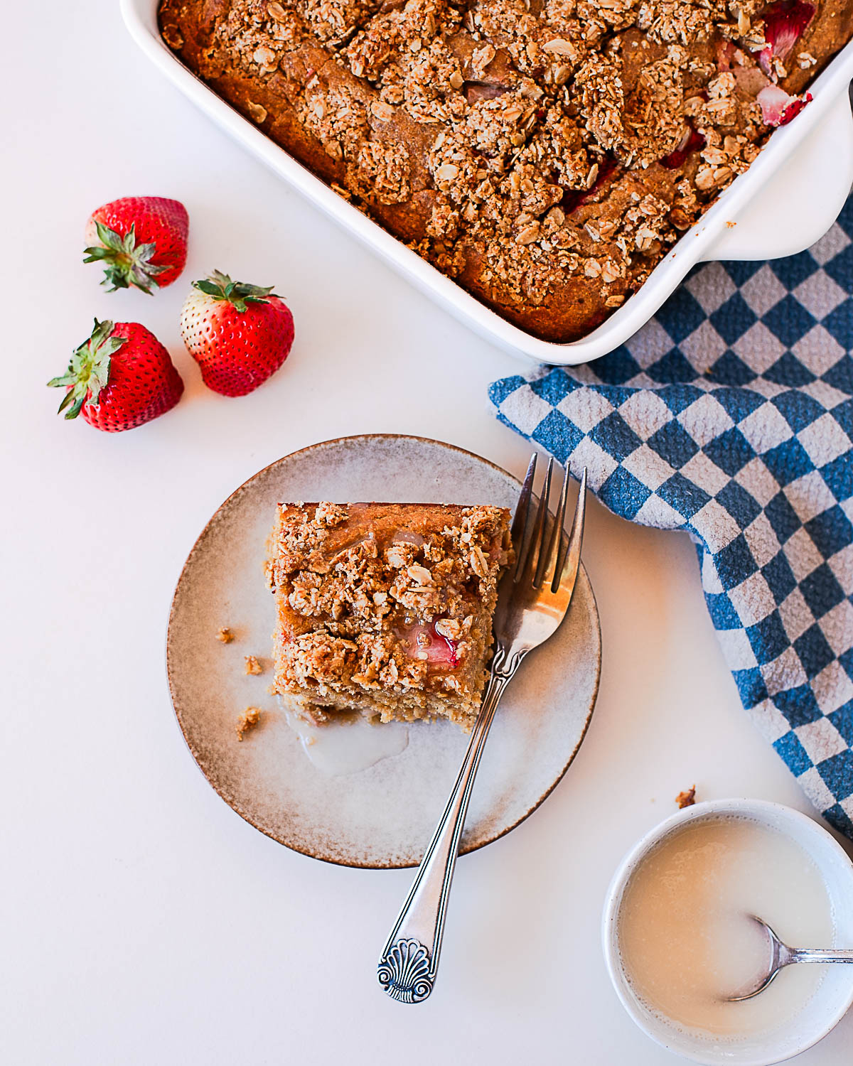 Overhead view of baked strawberry coffee cake with oats crumble and visible strawberries