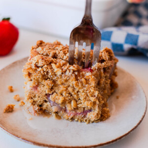 Strawberry coffee cake slice with crumb topping and fresh strawberries inside